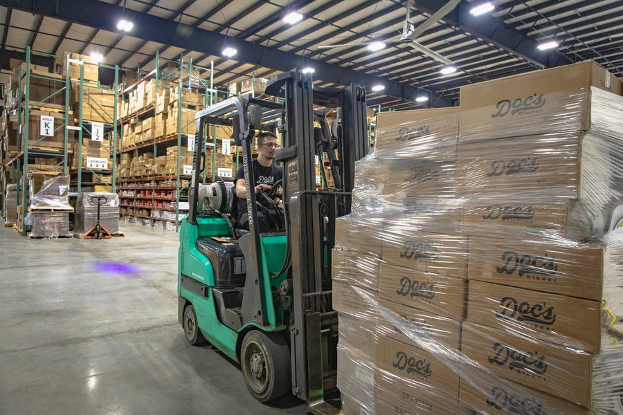 Forklift moving wrapped pallets of Doc's Diesel boxes