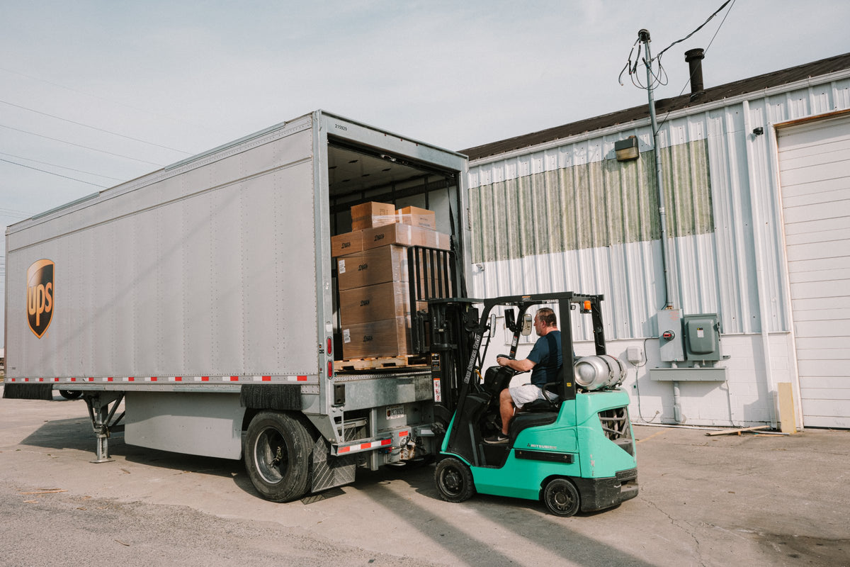 Forklift loading a semi trailer outside the Doc's Diesel warehouse