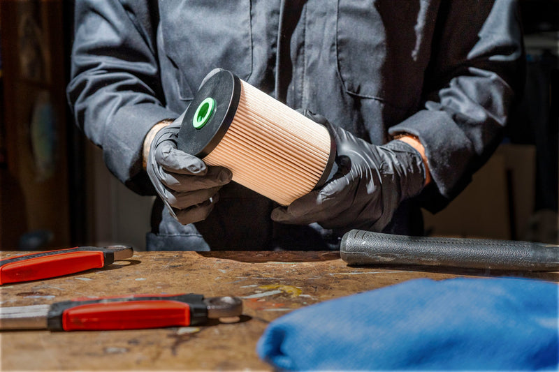 Gloved hands inspecting a Doc's Diesel fuel filter