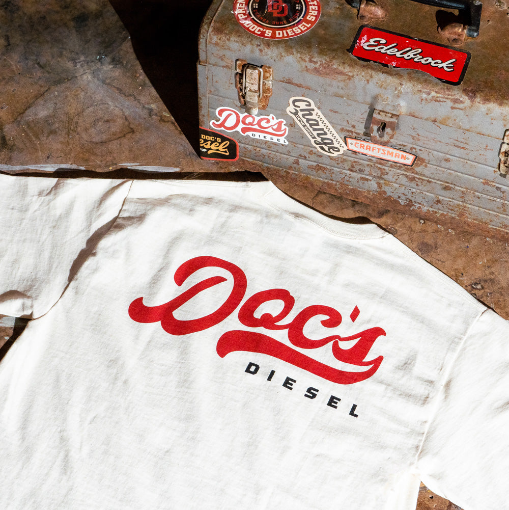 Doc's Diesel Tan Staple T-Shirt in a mechanic's shop
